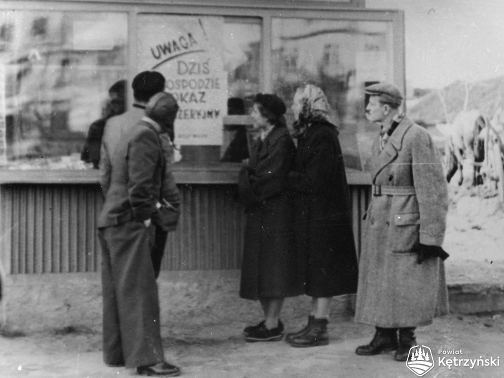 Srokowo, pracownicy Gminnej Spółdzielni (GS) podczas czytania afiszu - 1953r.