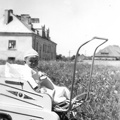 Edward Kamiński w wózeczku na tle domu pracowników cukrowni przy ul. Ogrodowej 1958r.