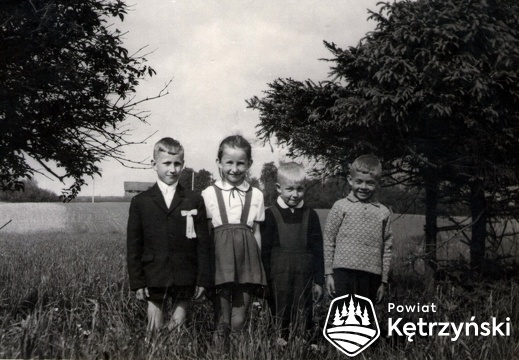 Grupa dzieci po uroczystościach I Komunii Św., w głębi tereny obecnej szkoły Powiatowe centrum Edukacyjne przy ul. Poznańskiej - 1969r.